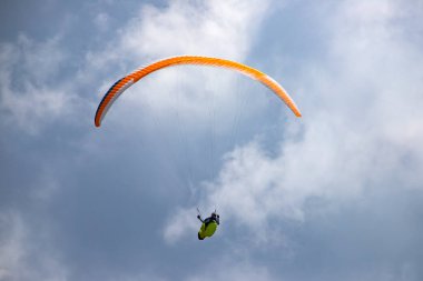 Mavi gökyüzünde bulutlarla uçan paraglider. Macera konsepti..