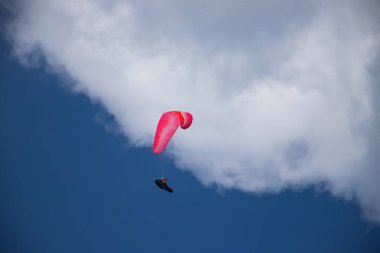 Mavi gökyüzünde bulutlarla uçan paraglider. Macera konsepti..