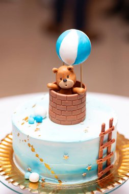 Tatlı ayıcıklı vaftizli pasta ve mavi sıcak hava balonu.
