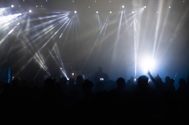 Konserde kalabalık - Parlak renkli sahne ışıkları önünde tezahürat yapan kalabalık