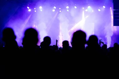 Konserde kalabalık - Parlak renkli sahne ışıkları önünde tezahürat yapan kalabalık