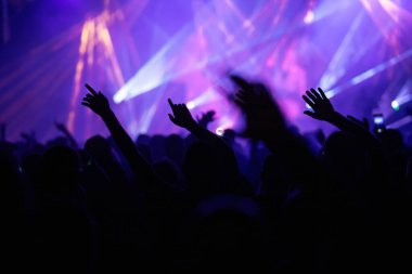 Konserde kalabalık - Parlak renkli sahne ışıkları önünde tezahürat yapan kalabalık