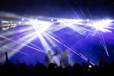 Konserde kalabalık - Parlak renkli sahne ışıkları önünde tezahürat yapan kalabalık