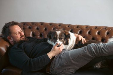 Evinde sevimli, mutlu köpeğiyle beyaz yakışıklı bir adam..