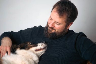 Evinde sevimli, mutlu köpeğiyle beyaz yakışıklı bir adam..