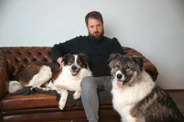 Evinde sevimli, mutlu köpekleri olan beyaz yakışıklı bir adam..