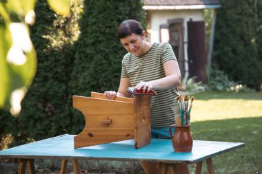 Evdeki mobilyaları zımparalayan kadın, yer değiştirme ve konsept..