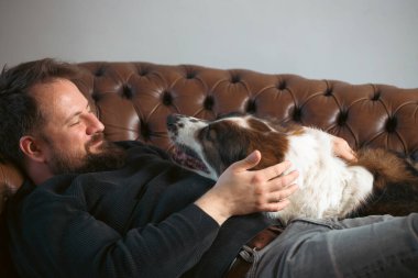 Evinde sevimli, mutlu köpeğiyle beyaz yakışıklı bir adam..