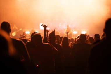 Konserde kalabalık - Parlak renkli sahne ışıkları önünde tezahürat yapan kalabalık