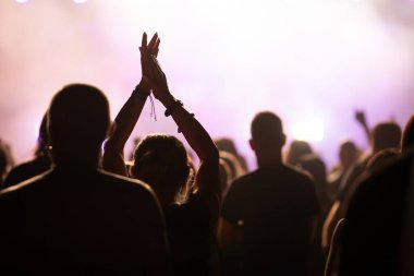 Konserde kalabalık - Parlak renkli sahne ışıkları önünde tezahürat yapan kalabalık