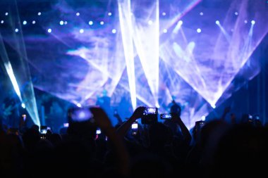 Konserde kalabalık - Parlak renkli sahne ışıkları önünde tezahürat yapan kalabalık