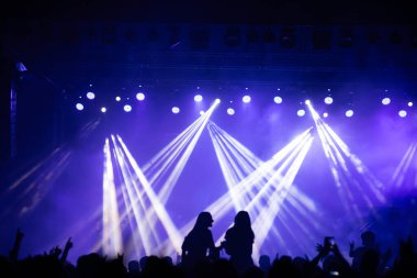 Konserde kalabalık - Parlak renkli sahne ışıkları önünde tezahürat yapan kalabalık