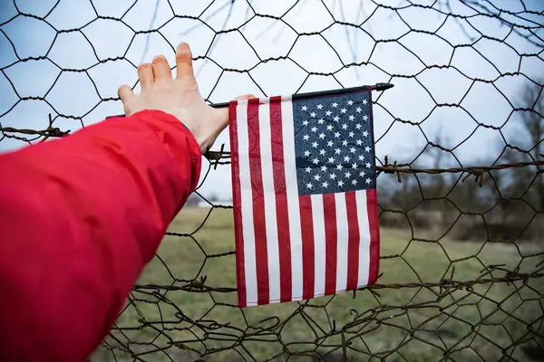 Zincirli tel örgüye bağlı bir Amerikan Bayrağı 'nı yakından çek. Amerikan göçmenlik ve ABD mülteci krizi kavramı