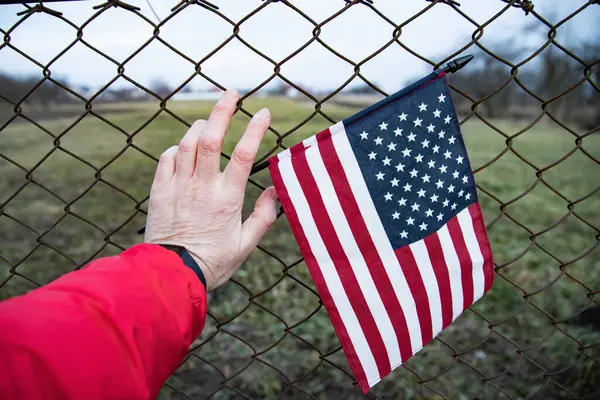 Zincirli tel örgüye bağlı bir Amerikan Bayrağı 'nı yakından çek. Amerikan göçmenlik ve ABD mülteci krizi kavramı