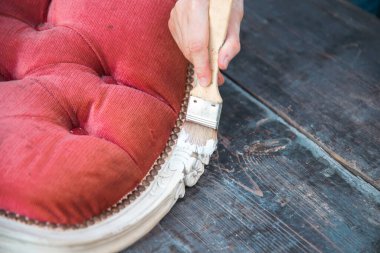 İnsan eli tebeşirle ahşap mobilya boyuyor. Yepyeni renkli tebeşir boyasıyla eski moda ahşap mobilyaları yeniliyorum. Ev dekorasyonu yeniden biçimlendiriliyor