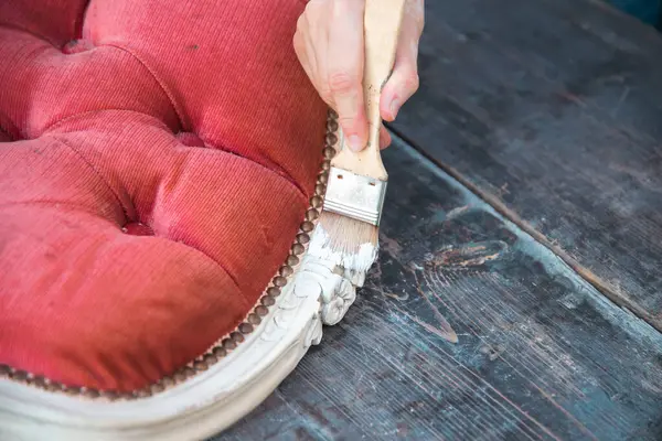 İnsan eli tebeşirle ahşap mobilya boyuyor. Yepyeni renkli tebeşir boyasıyla eski moda ahşap mobilyaları yeniliyorum. Ev dekorasyonu yeniden biçimlendiriliyor