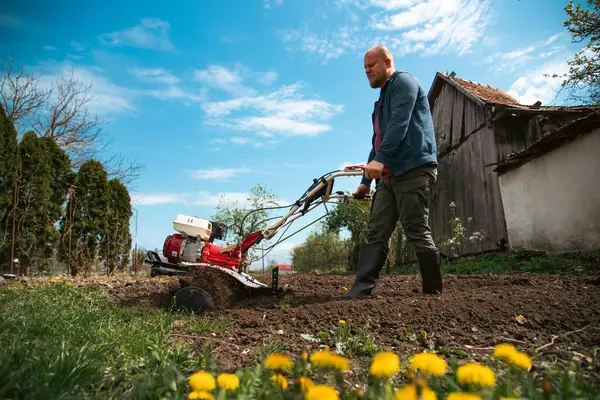 Bahçede Tiller 'la çalışan bir adam..