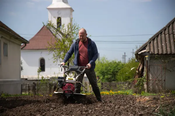 Bahçede Tiller 'la çalışan bir adam..