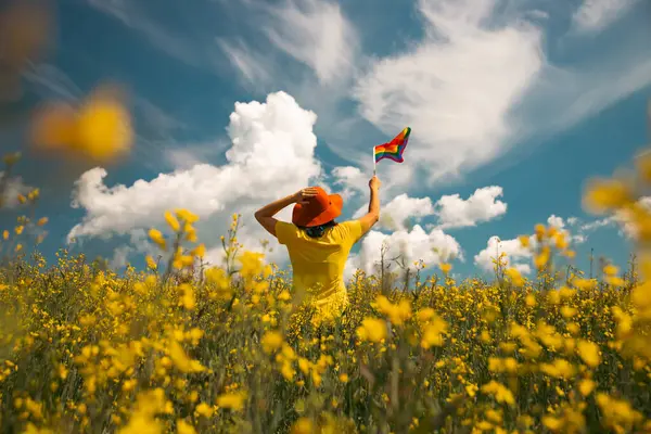Elinde Gay Gökkuşağı Bayrağı olan bir kadın. Aynı cinsiyet çiftleri için mutluluk, özgürlük ve aşk kavramı