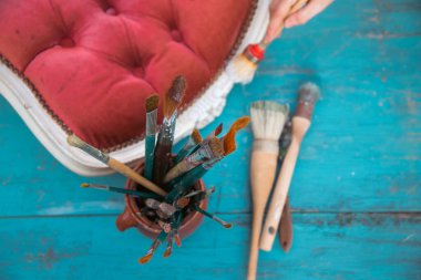 Çalışma masasında fırçalar ve mobilyalar. Yepyeni renkli tebeşir boyasıyla eski moda ahşap mobilyaları yeniliyorum.. 