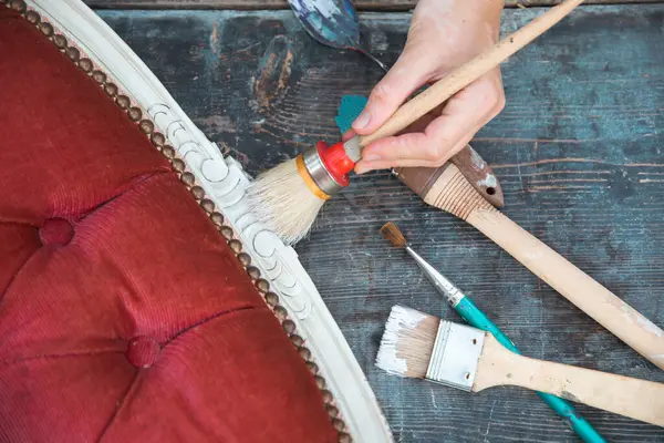 İnsan eli tebeşirle ahşap mobilya boyuyor. Yepyeni renkli tebeşir boyasıyla eski moda ahşap mobilyaları yeniliyorum. Ev dekorasyonu yeniden biçimlendiriliyor