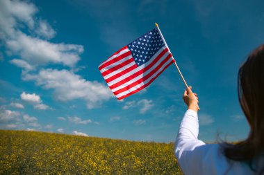Amerikan bayrağı tutan genç bir kadın. Bağımsızlık Günü ya da Amerika 'da seyahat. 