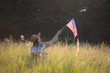 Amerikan bayrağı tutan genç bir kadın. Bağımsızlık Günü ya da Amerika 'da seyahat. 