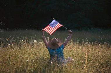 Amerikan bayrağı tutan genç bir kadın. Bağımsızlık Günü ya da Amerika 'da seyahat. 