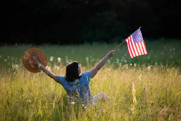 Amerikan bayrağı tutan genç bir kadın. Bağımsızlık Günü ya da Amerika 'da seyahat. 