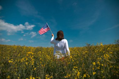 Amerikan bayrağı tutan genç bir kadın. Bağımsızlık Günü ya da Amerika 'da seyahat. 