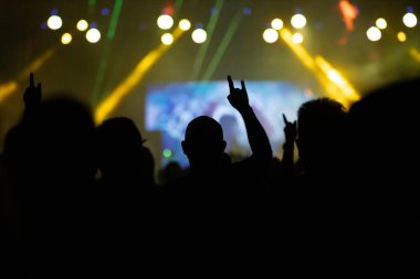 Konserde kalabalık - Parlak renkli sahne ışıkları önünde tezahürat yapan kalabalık