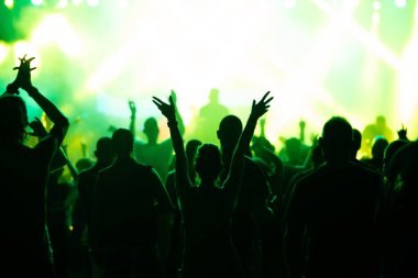 Konserde kalabalık - Parlak renkli sahne ışıkları önünde tezahürat yapan kalabalık