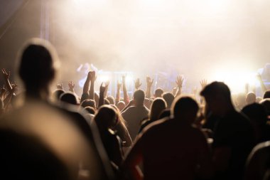 Konserde kalabalık - Parlak renkli sahne ışıkları önünde tezahürat yapan kalabalık