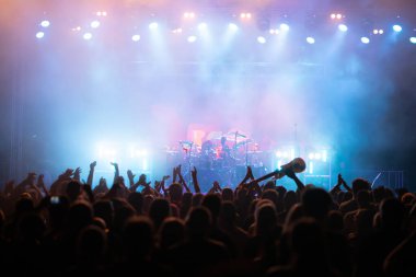 Konserde kalabalık - Parlak renkli sahne ışıkları önünde tezahürat yapan kalabalık