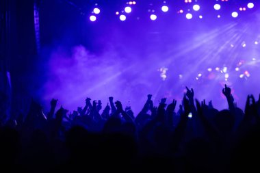 Konserde kalabalık - Parlak renkli sahne ışıkları önünde tezahürat yapan kalabalık