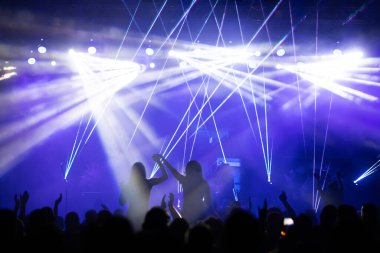 Konserde kalabalık - Parlak renkli sahne ışıkları önünde tezahürat yapan kalabalık
