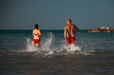 Kumsalda suda koşan mutlu baba ve kız. Babalar Günü konsepti.