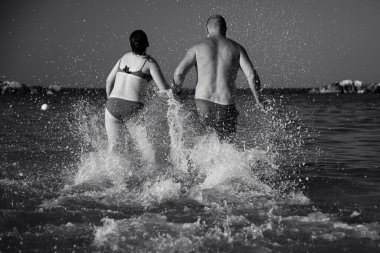 Kumsalda suda koşan mutlu baba ve kız. Babalar Günü konsepti.
