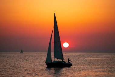 Canlı renkli günbatımı karşı onun yolculuğu boyunca yelken kontrast bir tekne ile yelkenli günbatımı fantezi