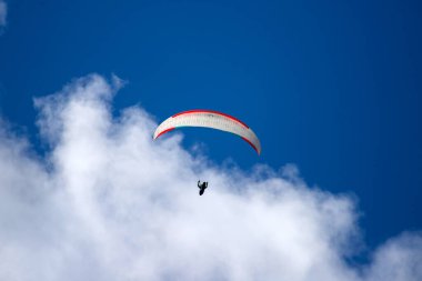 Mavi gökyüzünde bulutlarla uçan paraglider. Macera konsepti..