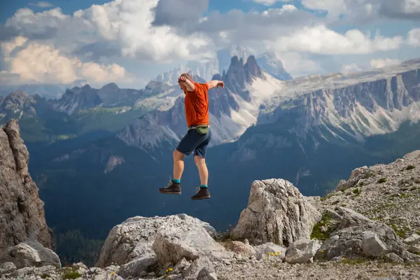 Gezgin ya da gezgin Dolomite dağlarında büyük kayalara atlıyor. Meydan okuma, risk ve özgürlük kavramı.