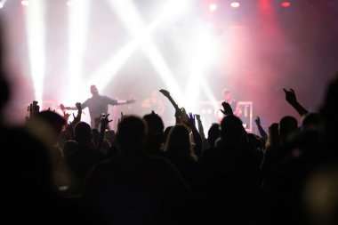 Konserde kalabalık - Parlak renkli sahne ışıkları önünde tezahürat yapan kalabalık