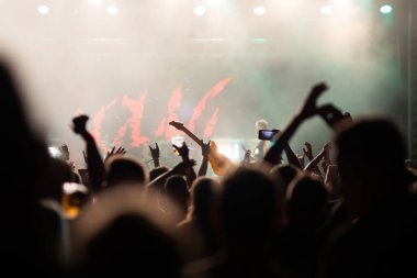 Konserde kalabalık - Parlak renkli sahne ışıkları önünde tezahürat yapan kalabalık