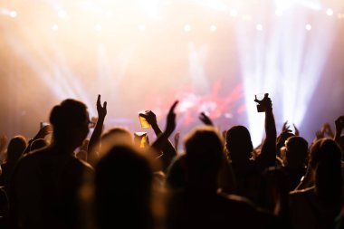 Konserde kalabalık - Parlak renkli sahne ışıkları önünde tezahürat yapan kalabalık