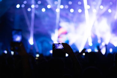 Konserde kalabalık - Parlak renkli sahne ışıkları önünde tezahürat yapan kalabalık