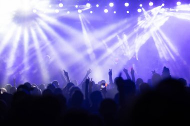 Konserde kalabalık - Parlak renkli sahne ışıkları önünde tezahürat yapan kalabalık