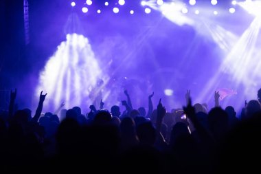 Konserde kalabalık - Parlak renkli sahne ışıkları önünde tezahürat yapan kalabalık