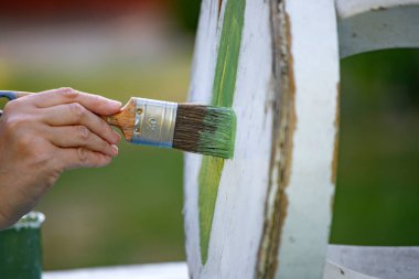 İnsan eli tebeşirle ahşap mobilya boyuyor. Yepyeni renkli tebeşir boyasıyla eski moda ahşap mobilyaları yeniliyorum. Ev dekorasyonu yeniden biçimlendiriliyor