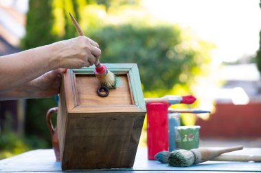 İnsan eli tebeşirle ahşap mobilya boyuyor. Yepyeni renkli tebeşir boyasıyla eski moda ahşap mobilyaları yeniliyorum. Ev dekorasyonu yeniden biçimlendiriliyor