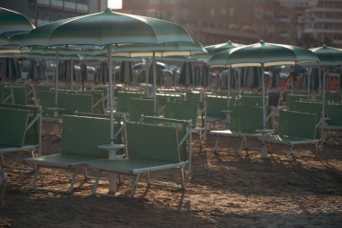 Yaz atmosferi, plaj şezlongları ve kumsaldaki şemsiyeler.